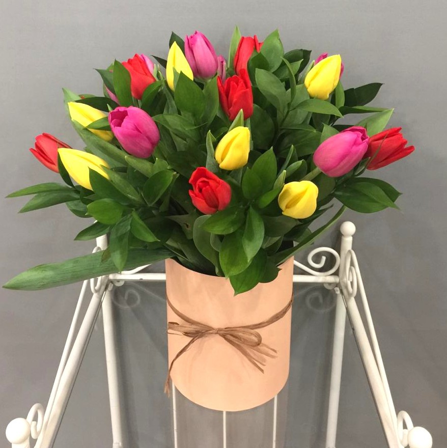 Букет из разноцветных тюльпанов в персиковой шляпной коробке